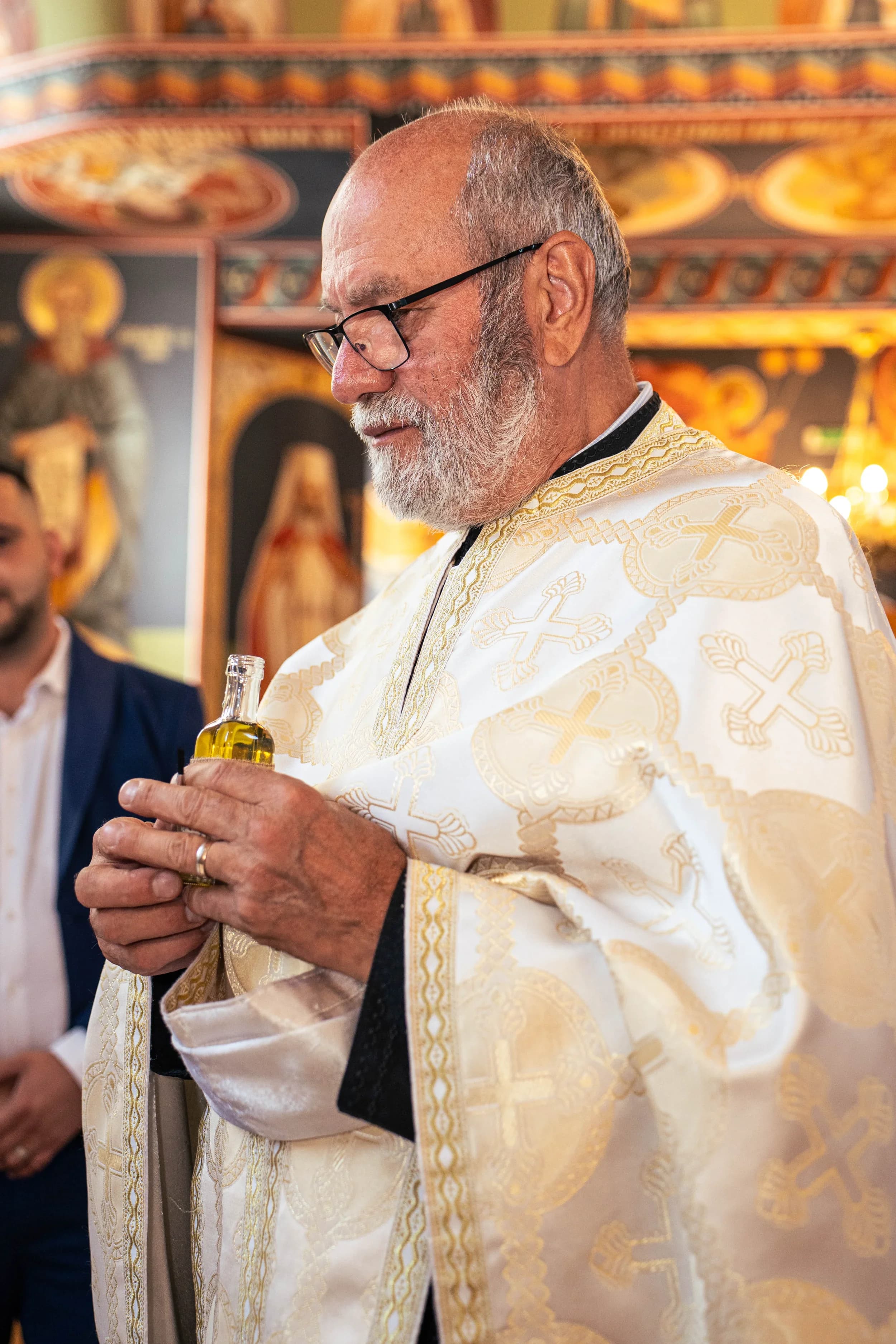 Moment emotionant cu preotul si uleiul de botez fotograf botez profesional Brasov Crudu Alexandru CA Photography