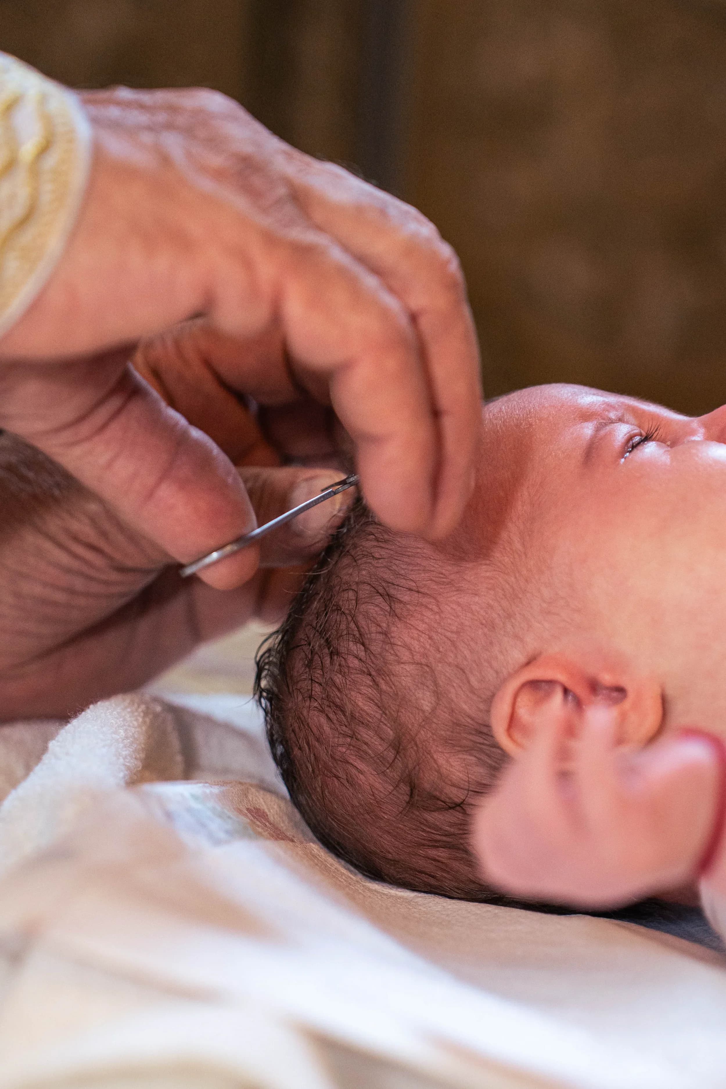 Moment emotionant al taierei parului bebelusului fotograf botez profesional Brasov Crudu Alexandru CA Photography