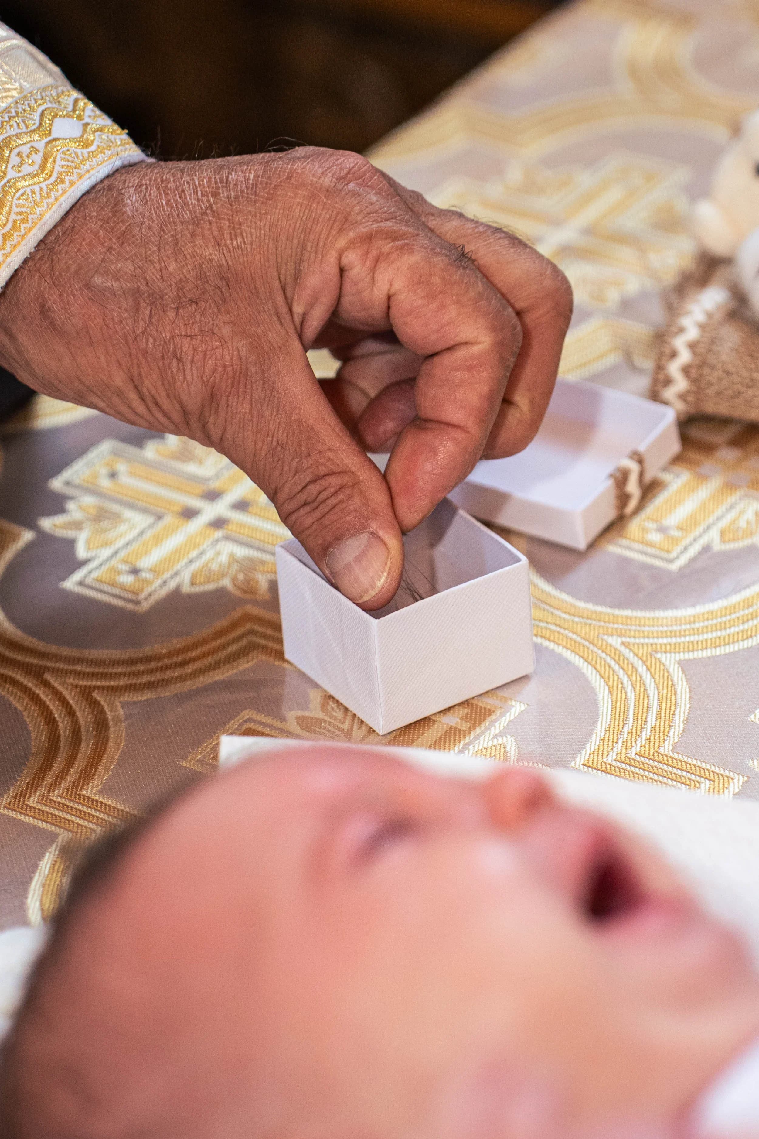 Mână de preot punând inel in cristelnita fotograf botez profesional Brasov Crudu Alexandru CA Photography