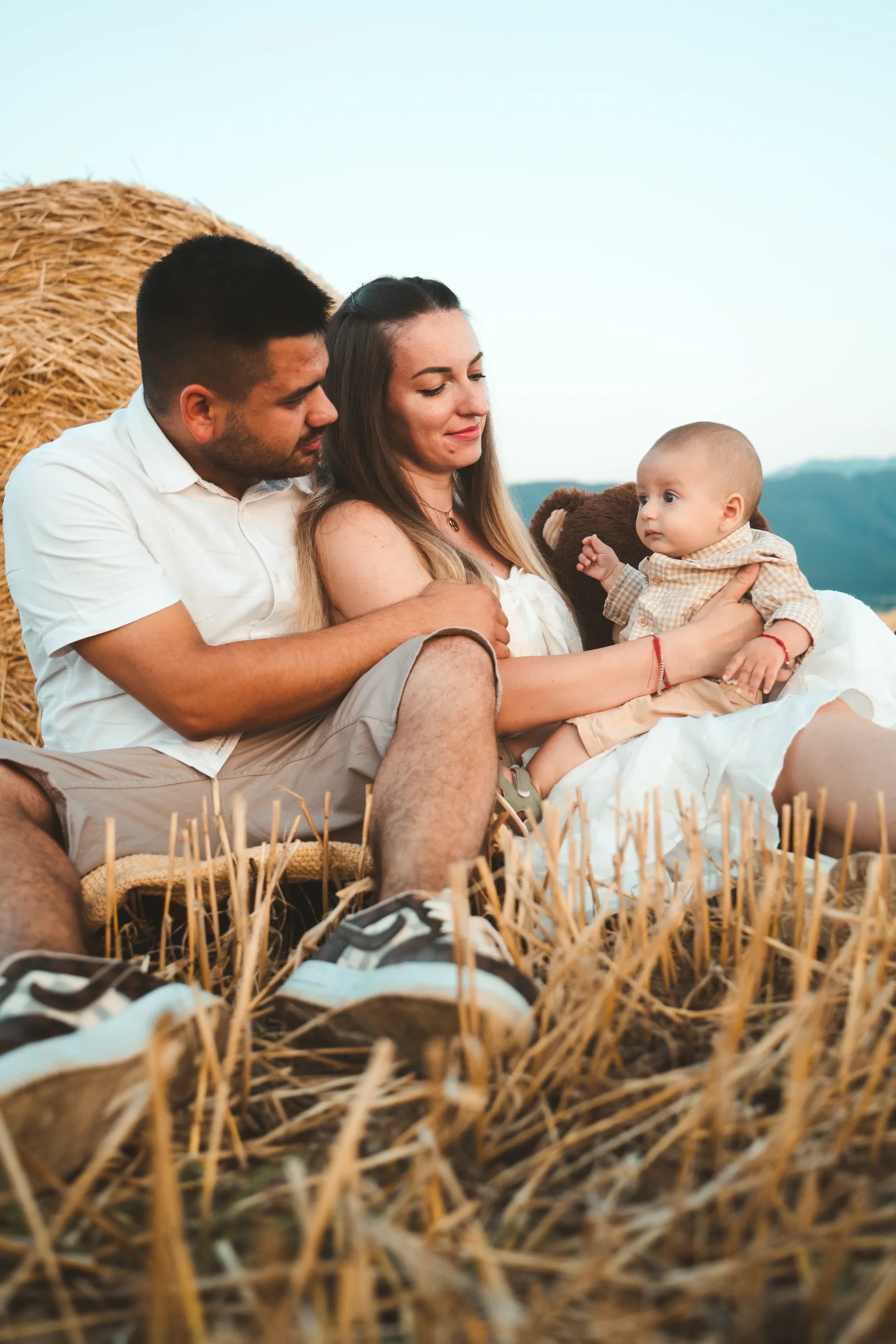 Parinte si mama tinand bebelusul pe fâneata fotograf familie sedinta foto studio Brasov Crudu Alexandru CA Photography