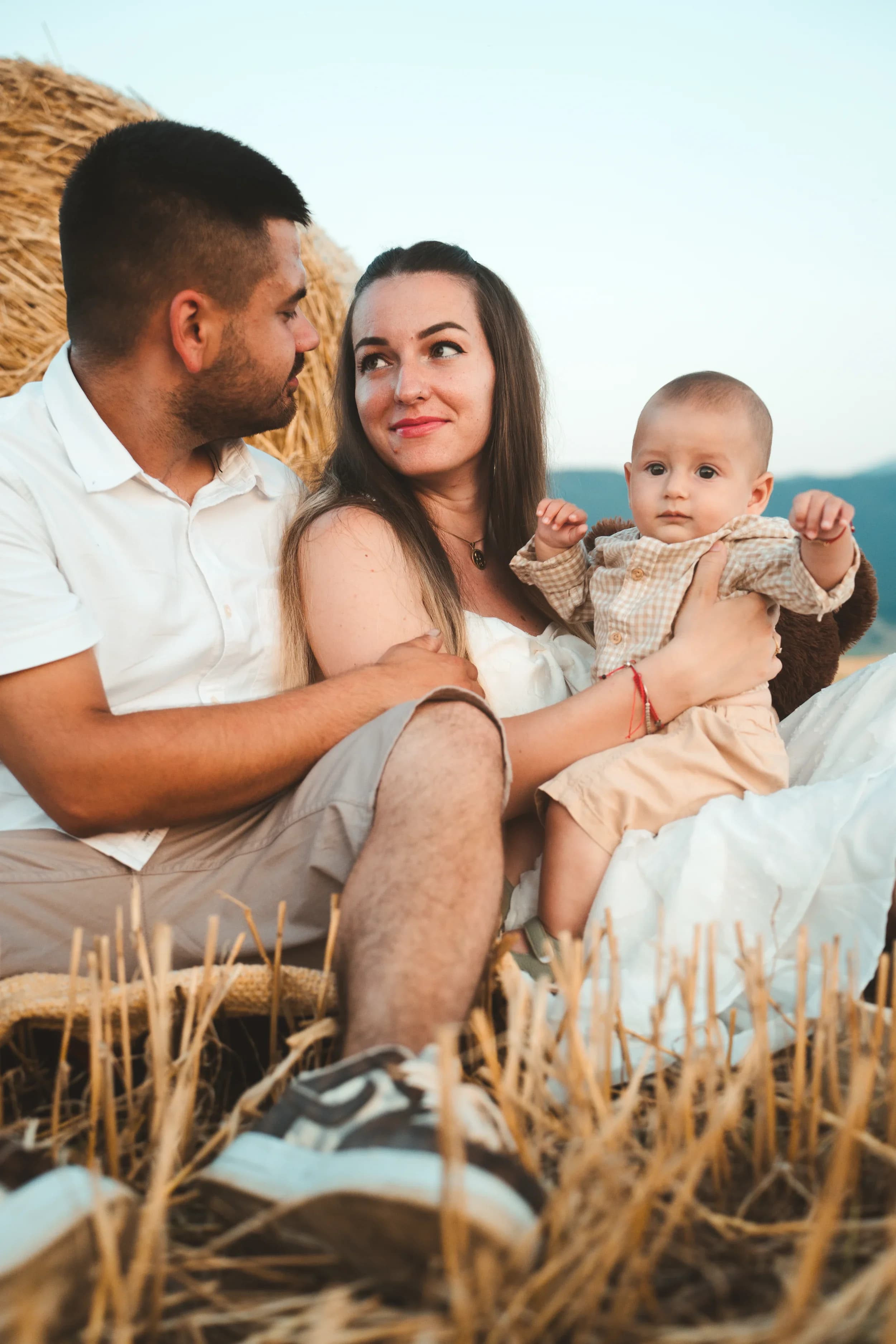 Familie zambind si tinand copilul pe camp fotograf familie sedinta foto studio Brasov Crudu Alexandru CA Photography