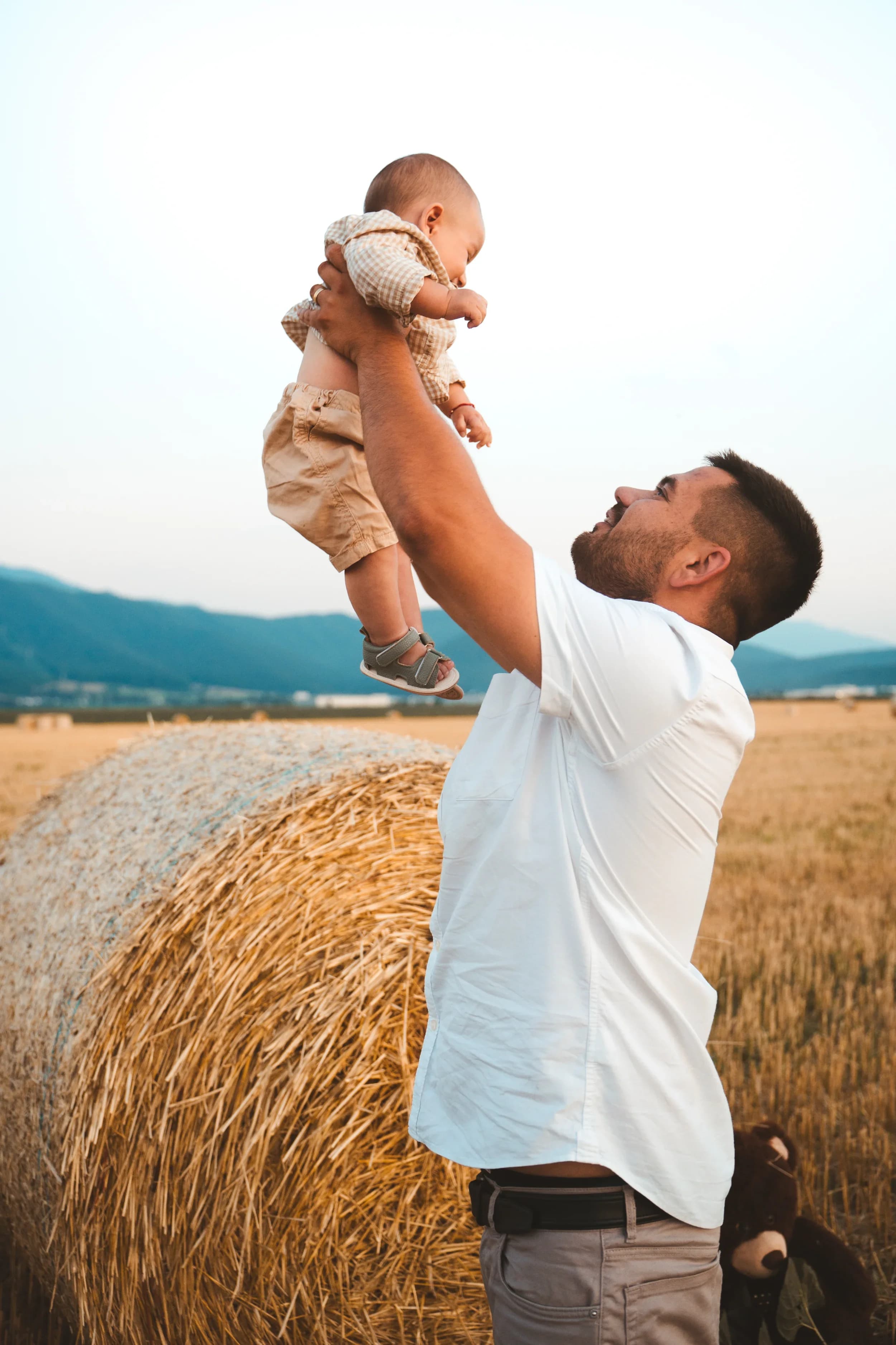 Tata ridicand copilul in aer pe camp de faneata fotograf familie sedinta foto studio Brasov Crudu Alexandru CA Photography