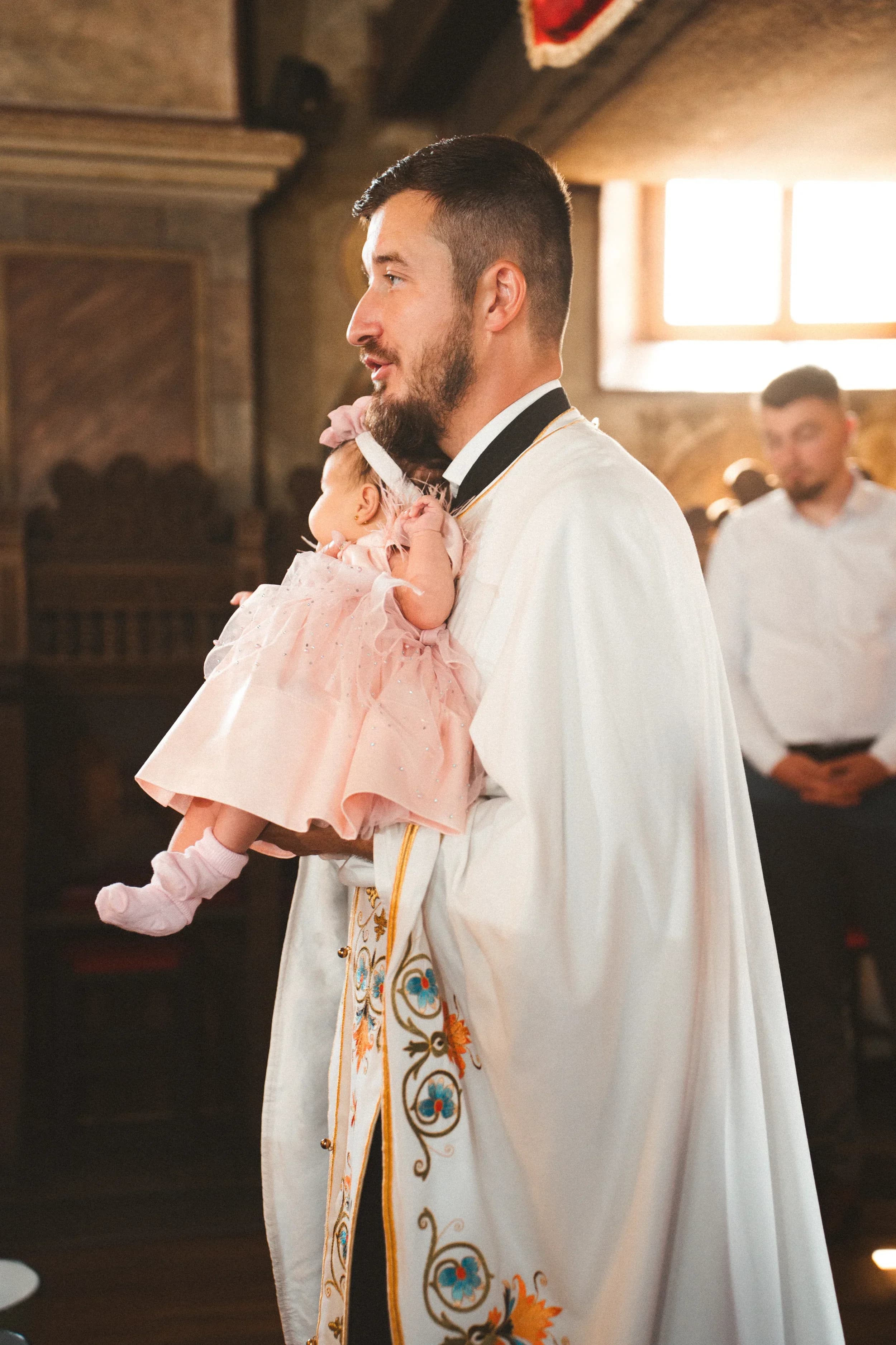 Preot cu bebelus in brate fotograf botez profesional Brasov Crudu Alexandru CA Photography