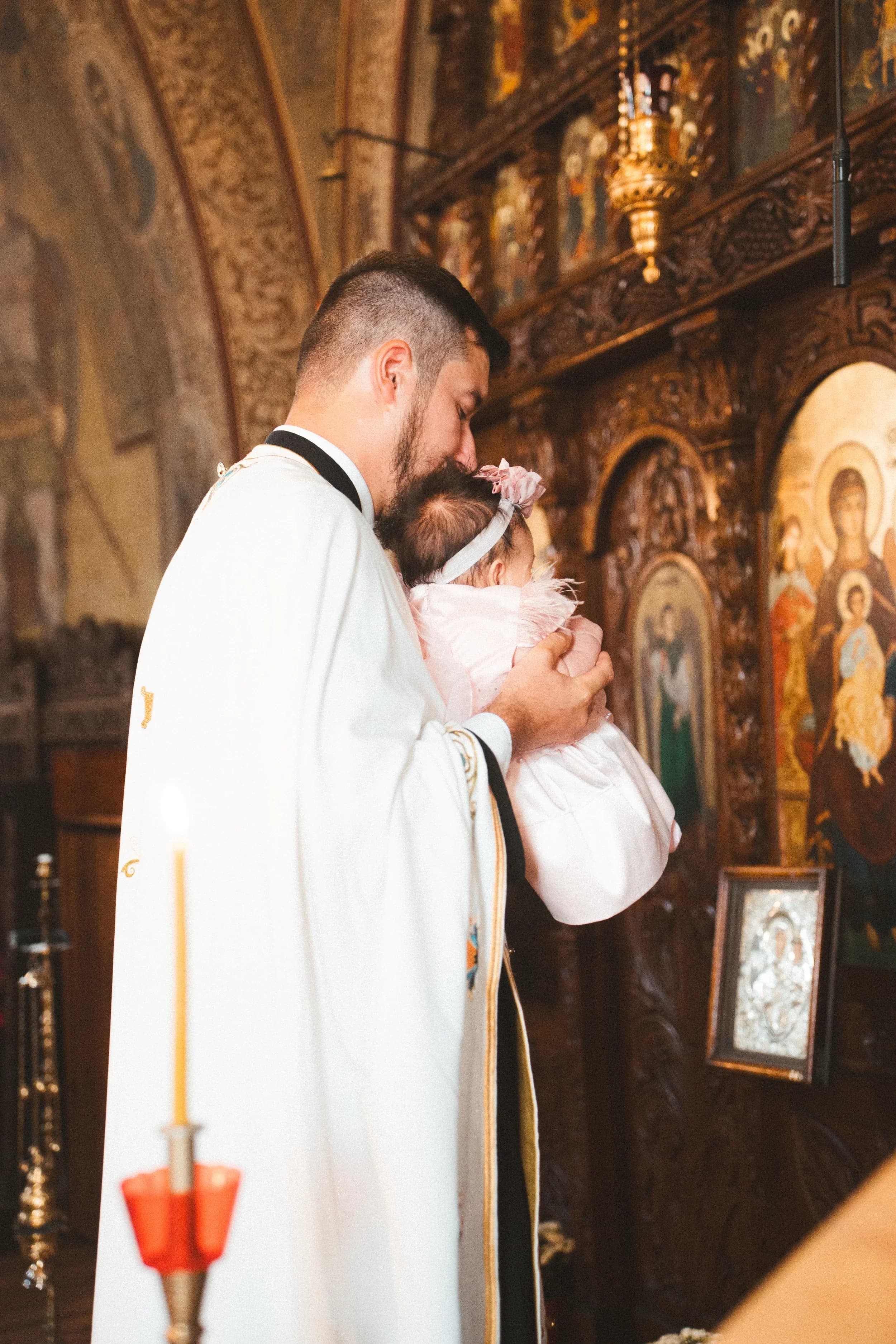 Tata imbratisand bebelusul la biserica fotograf botez profesional Brasov Crudu Alexandru CA Photography