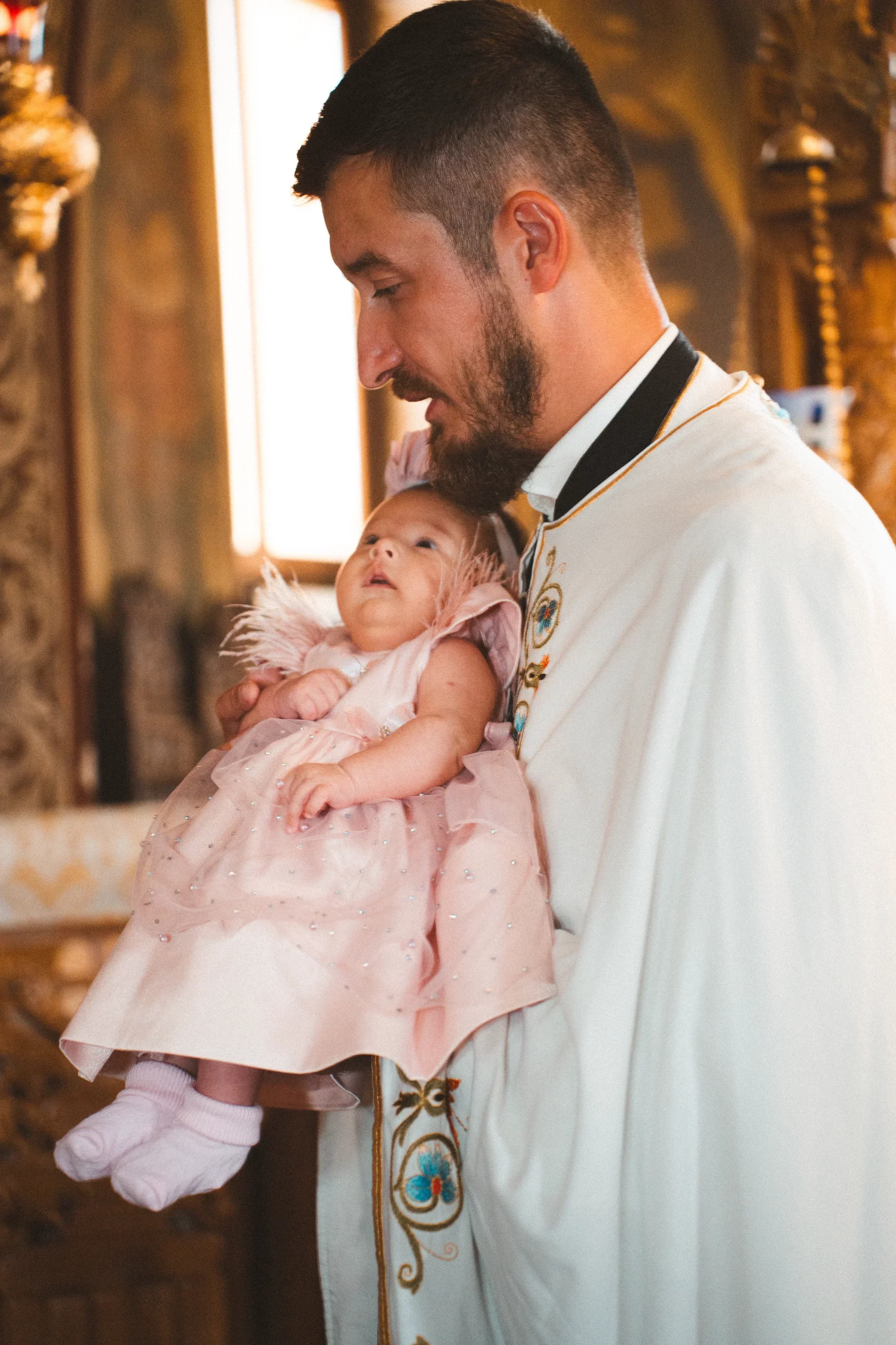 Moment emotionant cu bebelusul in bratele naselului fotograf botez profesional Brasov Crudu Alexandru CA Photography